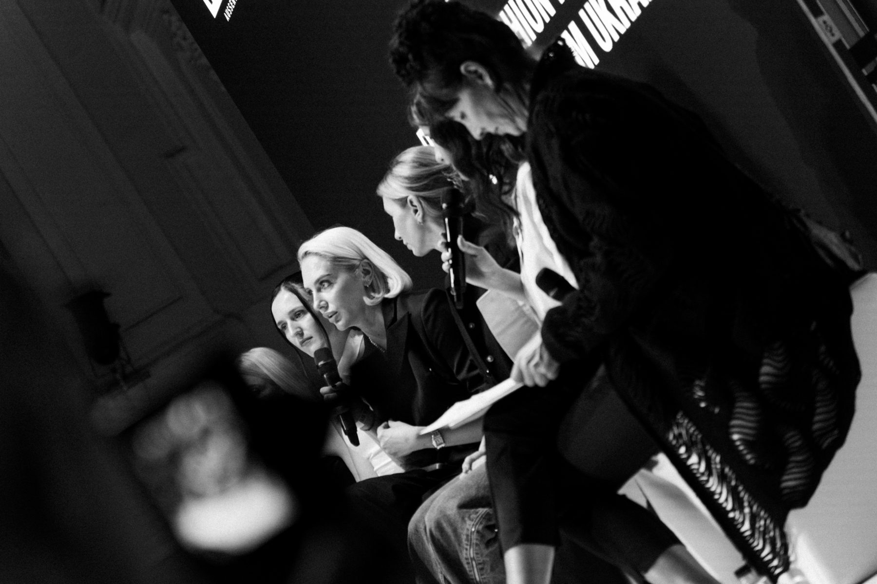 Black-and-white photograph of a panel discussion at a corporate event