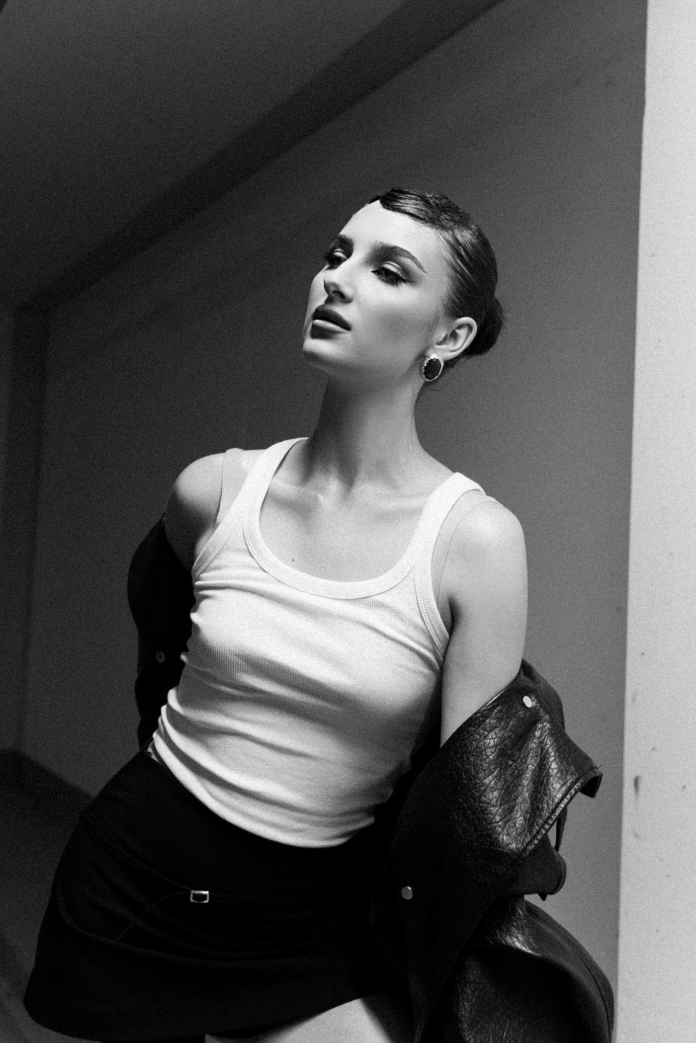 Black-and-white portrait of a woman in a white top and leather jacket